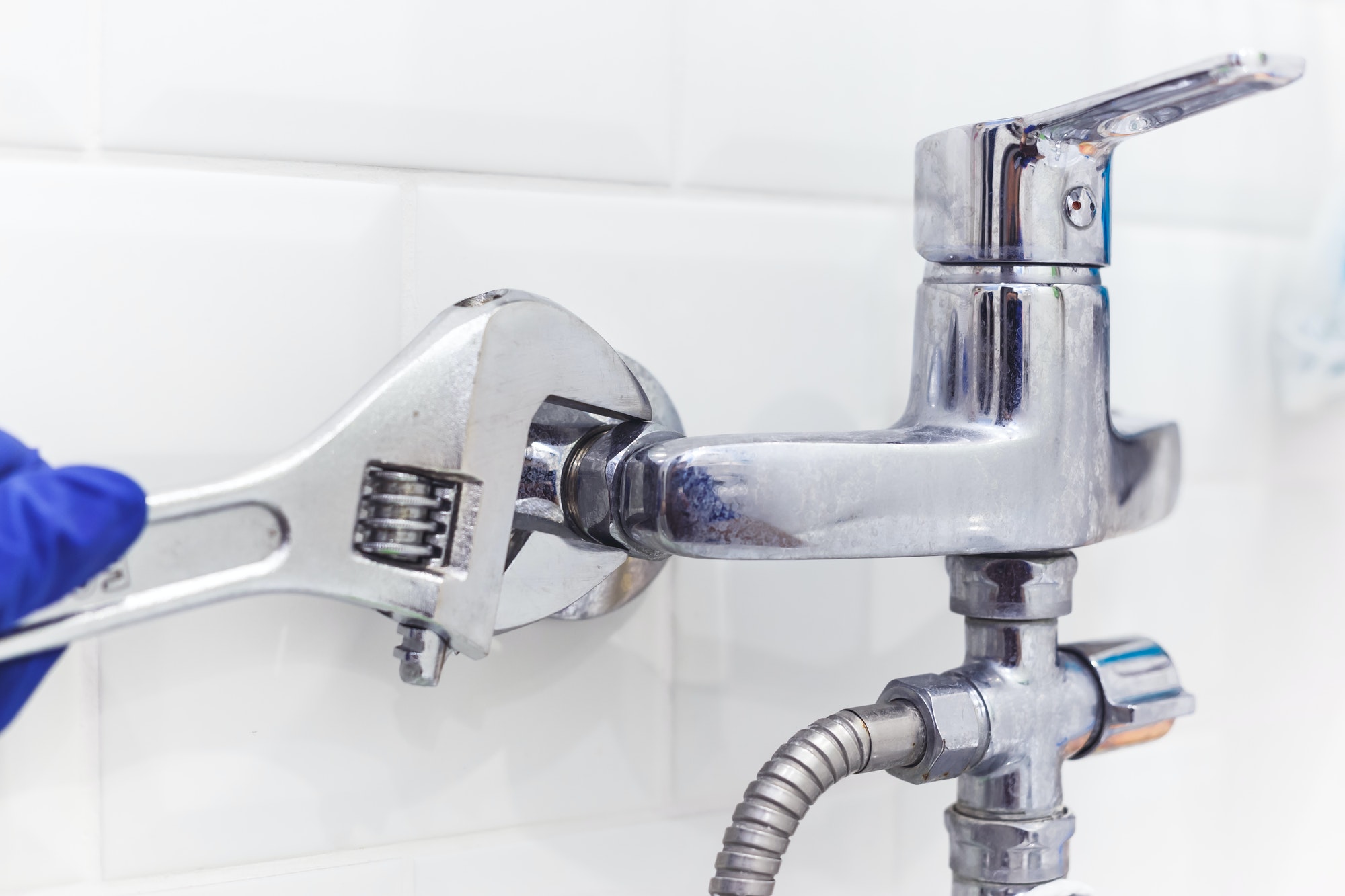 plumber-uses-pipe-wrench-for-service-shower-mixer-tap.jpg