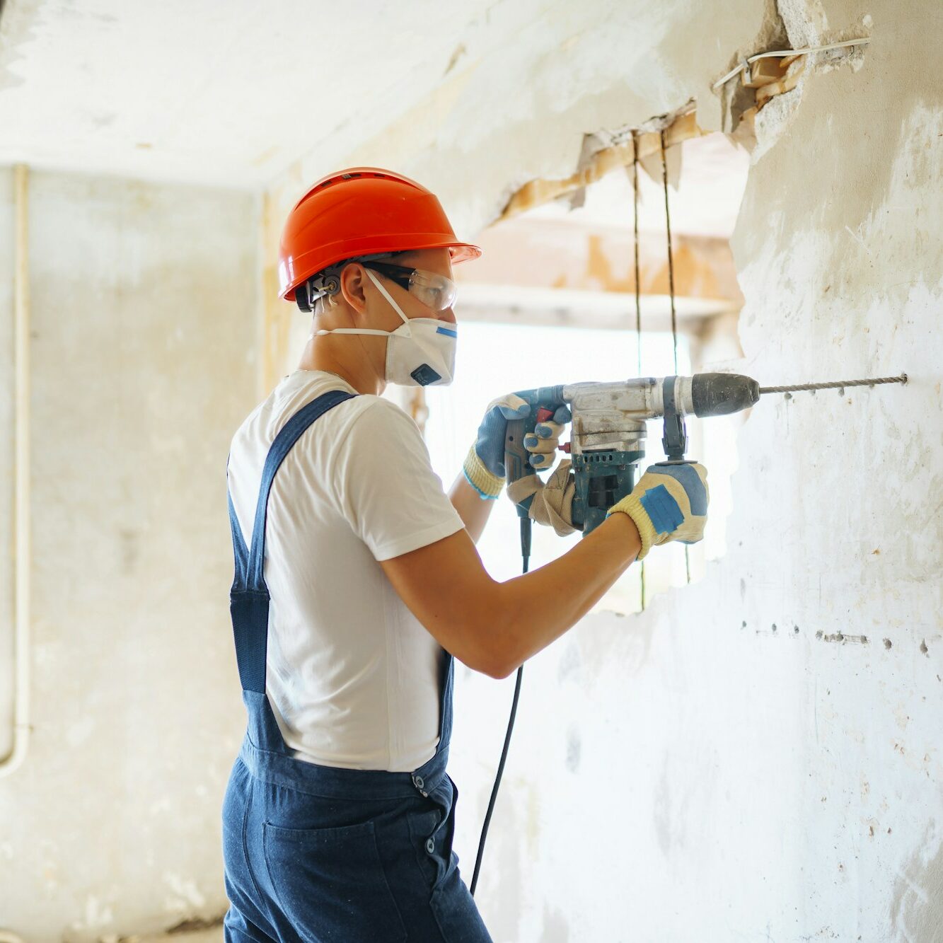 Repairer in boilersuit holding tools. Apartment repair and renovation concept. Building.